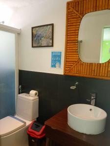 a bathroom with a sink and a toilet and a mirror at SG Tourist Inn in El Nido