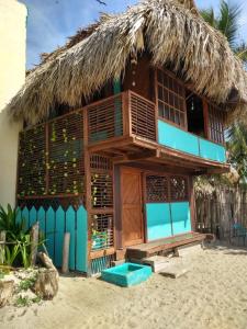 Casa Akira- Rincón del Mar في San Onofre: منزل على الشاطئ مع سقف من القش
