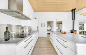 a kitchen with white cabinets and a wooden ceiling at Gorgeous Home In Tarm With Sauna in Tarm