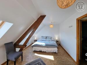 - une chambre mansardée avec un lit et une chaise dans l'établissement Gîte Landas, 3 pièces, 4 personnes - FR-1-510-191, à Landas