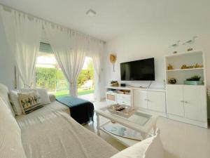 uma sala de estar branca com um sofá e uma televisão em Apartamento Miami Playa, 2 dormitorios, 4 personas - ES-9-167 em Les Planes del Rei