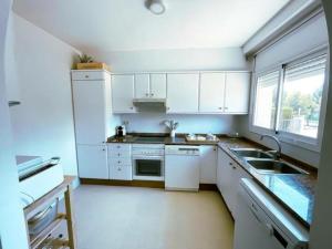 uma cozinha com armários brancos, um lavatório e uma janela em Apartamento Miami Playa, 2 dormitorios, 4 personas - ES-9-167 em Les Planes del Rei