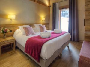 a bedroom with a large bed with a red blanket at Chalet La Clusaz, 4 pièces, 6 personnes - FR-1-304-287 in La Clusaz