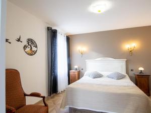 a bedroom with a white bed and a chair at Maison Familiale au Calme avec Ping-Pong, Baby-Foot et Proximité Sites Préhistoriques - FR-1-616-339 in Le Bugue