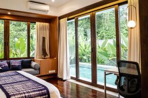Un dormitorio con una cama y una ventana grande. en Villa Leceni Canggu by Nakula, en Canggu