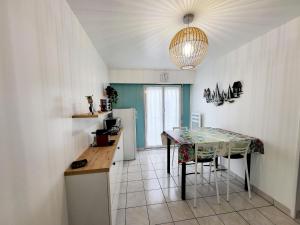a kitchen with a table with chairs and a refrigerator at Appartement Les Sables-d'Olonne, 2 pièces, 4 personnes - FR-1-92-937 in Les Sables-d'Olonne