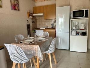 eine Küche mit einem Tisch mit Stühlen und einem Kühlschrank in der Unterkunft Appartement Mandelieu-la-Napoule, 1 pièce, 3 personnes - FR-1-609-96 in Mandelieu-la-Napoule
