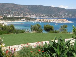 ein Blick auf einen Strand und ein Gewässer in der Unterkunft T2 climatisé 3* avec Loggia, Parking sécurisé, WiFi, proche plage - Bormes-les-Mimosas - FR-1-610-98 in Bormes-les-Mimosas