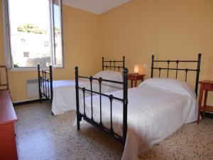 een slaapkamer met 2 bedden met witte lakens en een raam bij Appartement Mèze, 4 pièces, 4 personnes - FR-1-604-46 in Mèze