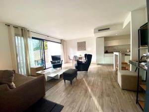 ein Wohnzimmer mit einem Sofa und Stühlen sowie eine Küche in der Unterkunft Calme Villa Plain-Pied à Bouzigues, Proche Plage et Commerces, 3*** - FR-1-604-45 in Bouzigues