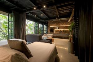 een slaapkamer met een bed en stoelen en een open haard bij Hotel Meridiano Lofts in Medellín