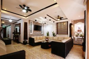 un salon avec un canapé et une télévision dans l'établissement Coron Bancuang Mansion, à Coron