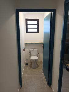 a bathroom with a toilet with a window in it at Case Lénora in Saint-Joseph