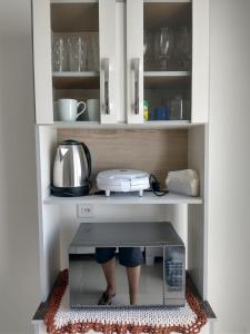 una persona parada dentro de un microondas en una cocina en Casa em Condomínio Fechado, en Pelotas