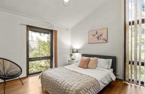 a bedroom with a bed and a large window at Tsapas Homes in Doncaster East