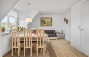 a dining room with a table and chairs and a couch at 1 Bedroom Nice Apartment In Thyborøn in Thyborøn