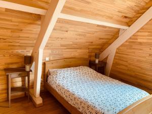 - une chambre avec un lit dans une maison en bois dans l'établissement Moulin d’Eysus - Le Moulin, à Eysus