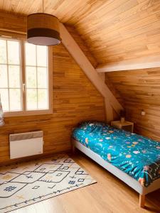 - une chambre avec un lit dans une pièce dotée de murs en bois dans l'établissement Moulin d’Eysus - Le Moulin, à Eysus