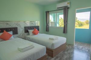 2 camas con almohadas de color naranja en una habitación en Anatasia Apartment Phuket en Phuket