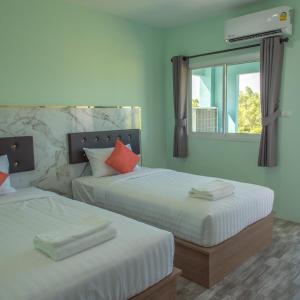 2 camas en una habitación con ventana en Anatasia Apartment Phuket en Phuket