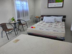 Schlafzimmer mit einem Bett, einem Tisch und Stühlen in der Unterkunft Homestay Erna Tanjong Tinggi in Pasarbaru