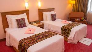 Postel nebo postele na pokoji v ubytování Hotel Grand Continental Kuching