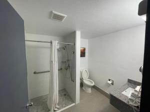 uma casa de banho com um chuveiro e um WC. em Days Inn by Wyndham Shawnee em Shawnee