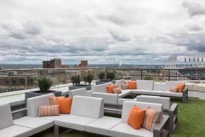 a rooftop patio with white couches and orange pillows at Metropolitan at The 9, Autograph Collection in Cleveland