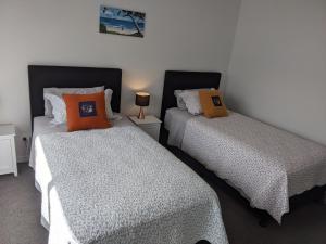 two beds sitting next to each other in a room at Cozy Cottage on Begg Lane in Cromwell