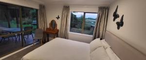 a bedroom with a bed and a table and a window at Dewdrop Cottage in Hastings