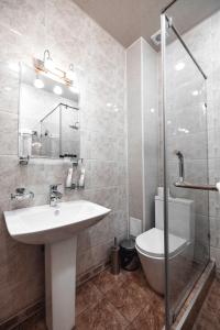 a bathroom with a sink and a toilet and a mirror at Art Regency Premium Hotel, Free Airport Shuttle Service in Tashkent