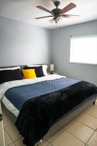 a bedroom with a large bed with a ceiling fan at 5 Mins from Clearwater Beach with Free Wi-Fi & TV in Clearwater