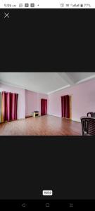 ein leeres Zimmer mit roten Vorhängen und Holzboden in der Unterkunft H R Palace in Dīgha