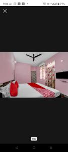 ein rosafarbenes Schlafzimmer mit einem großen Bett mit roten Kissen in der Unterkunft H R Palace in Dīgha