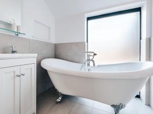 a white bathroom with a tub and a sink at The Hollow At The Linhay in Sawtry