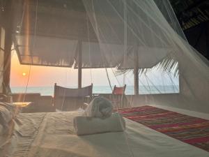 a bed with a towel on it with the ocean at Casa Akira- Rincón del Mar in San Onofre