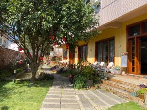 uma casa com cadeiras e uma árvore no quintal em YangShuo Eden Inn em Yangshuo