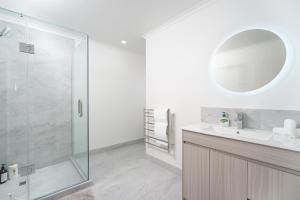a bathroom with a shower and a sink and a mirror at Charming 4bds House with 3 bathrooms Brand New in Hamilton +24 photos