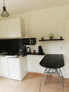 een keuken met een zwarte stoel en een magnetron bij jeanguy andrieu in Labruguière