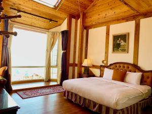 a bedroom with a bed and a large window at The Cotswolds Villa in Ren'ai