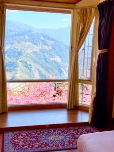 a bedroom with a large window with a mountain view at The Cotswolds Villa in Ren'ai