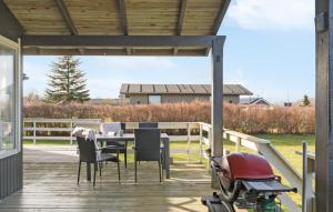 un patio con una mesa y un scooter aparcado en una terraza en Cozy Home In Glesborg With Kitchen, en Glesborg 6 fotos más