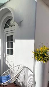 een paar stoelen op een veranda met een raam bij CAPRI DESIGN ROOM in Capri