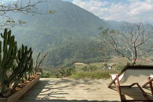 une chaise assise sur une terrasse avec vue sur la montagne dans l'établissement Pavi home, à Sa Pa