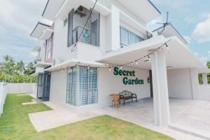 a white house with a sign for a secret garden at Kuala Selangor Secret Garden@KTV(walk to McDonald) in Kuala Selangor