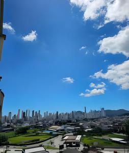 eine Skyline der Stadt mit blauem Himmel und Wolken in der Unterkunft PC803 - AP Grande, 1 Suíte, 1 Quarto, 90m2, até 6 pessoas in Balneário Camboriú