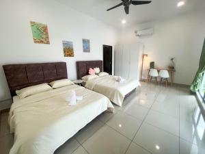 2 letti in una camera con pareti bianche di Desaru 20Pax Cozy Chill villa Private Pool a Johor Bahru