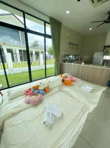 ein großes weißes Bett mit ausgestopften Tieren darauf in der Unterkunft Desaru 20Pax Cozy Chill villa Private Pool in Johor Bahru