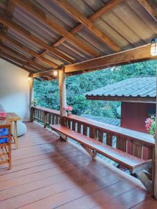 a wooden deck with benches and a table on it at Chadatarn HomeStay in Ban Pok Nai