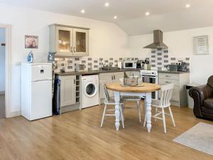 a kitchen with a table and chairs and a kitchen with a stove at Belton Cottage - Uk44745 in Tetford